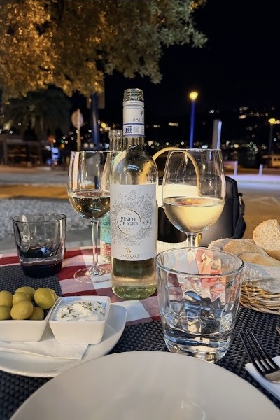 Mesa en terraza al atardecer con vino blanco